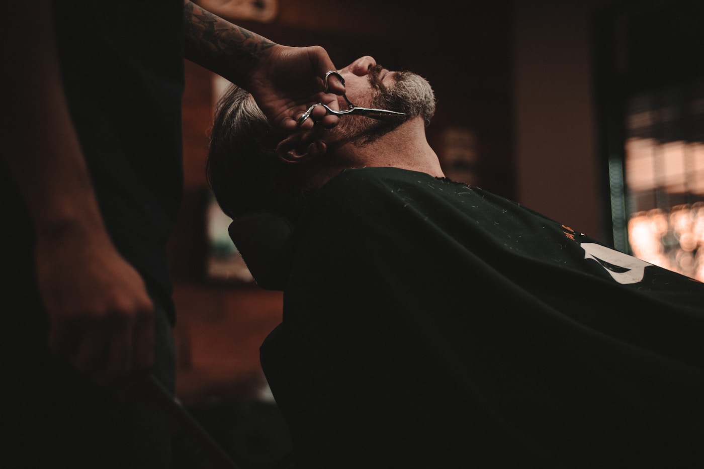 A barber focused on a haircut